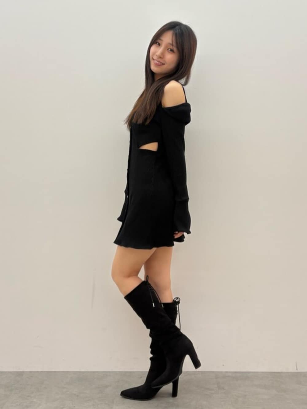 ブラック系のワンピース、その他のブーツを着用したレディースの秋コーディネートの2枚目の写真