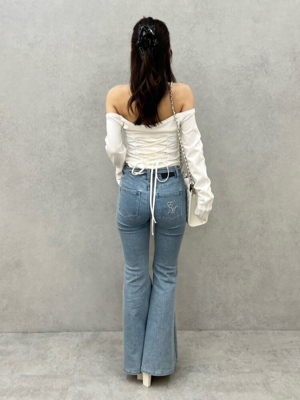 ブルー系のデニムパンツ、ホワイト系のTシャツ/カットソー、ホワイト系のサンダルを着用したレディースの春コーディネートの3枚目の写真