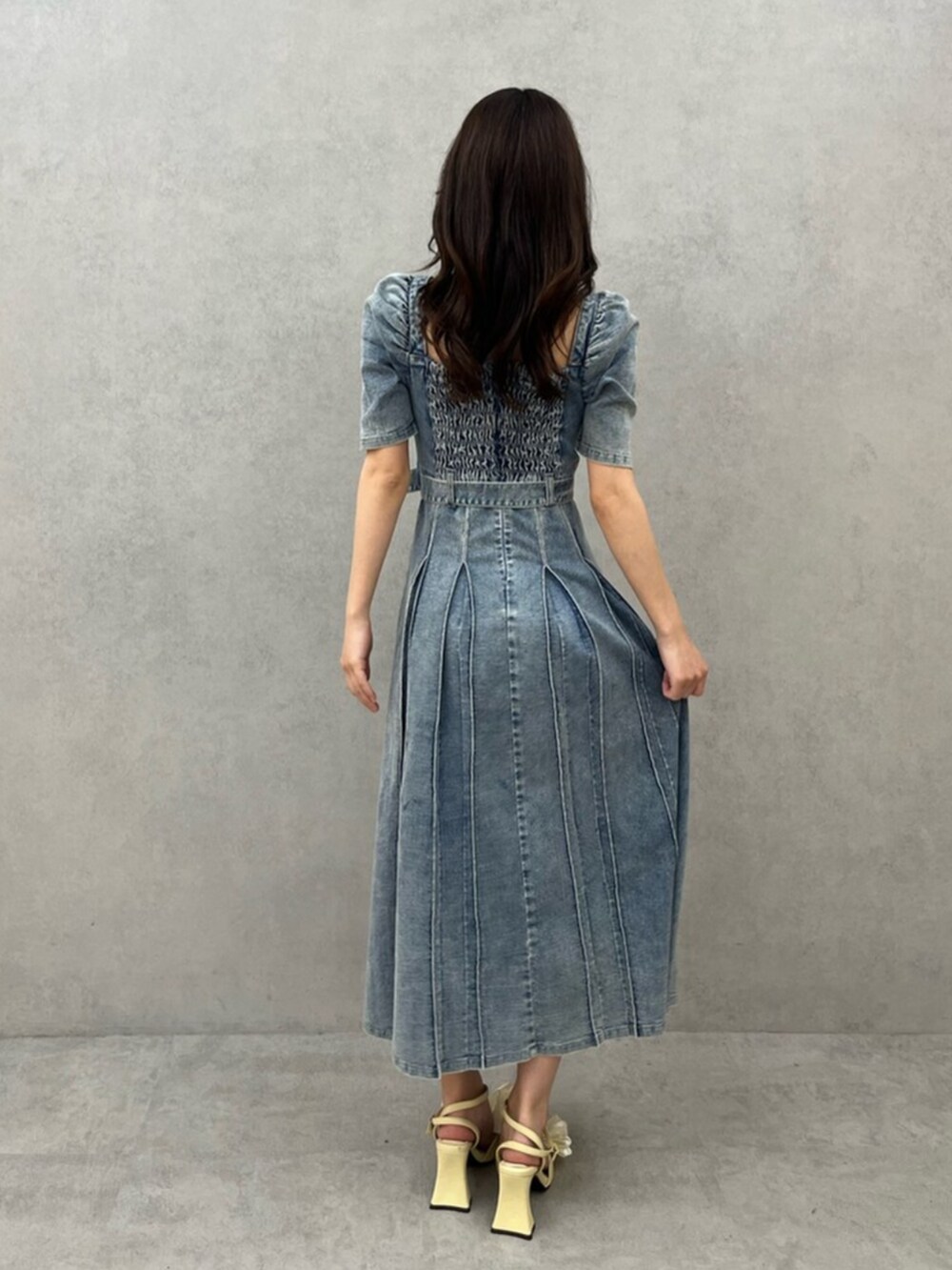 ブルー系のワンピース、イエロー系のパンプスを着用したレディースの春コーディネートの3枚目の写真