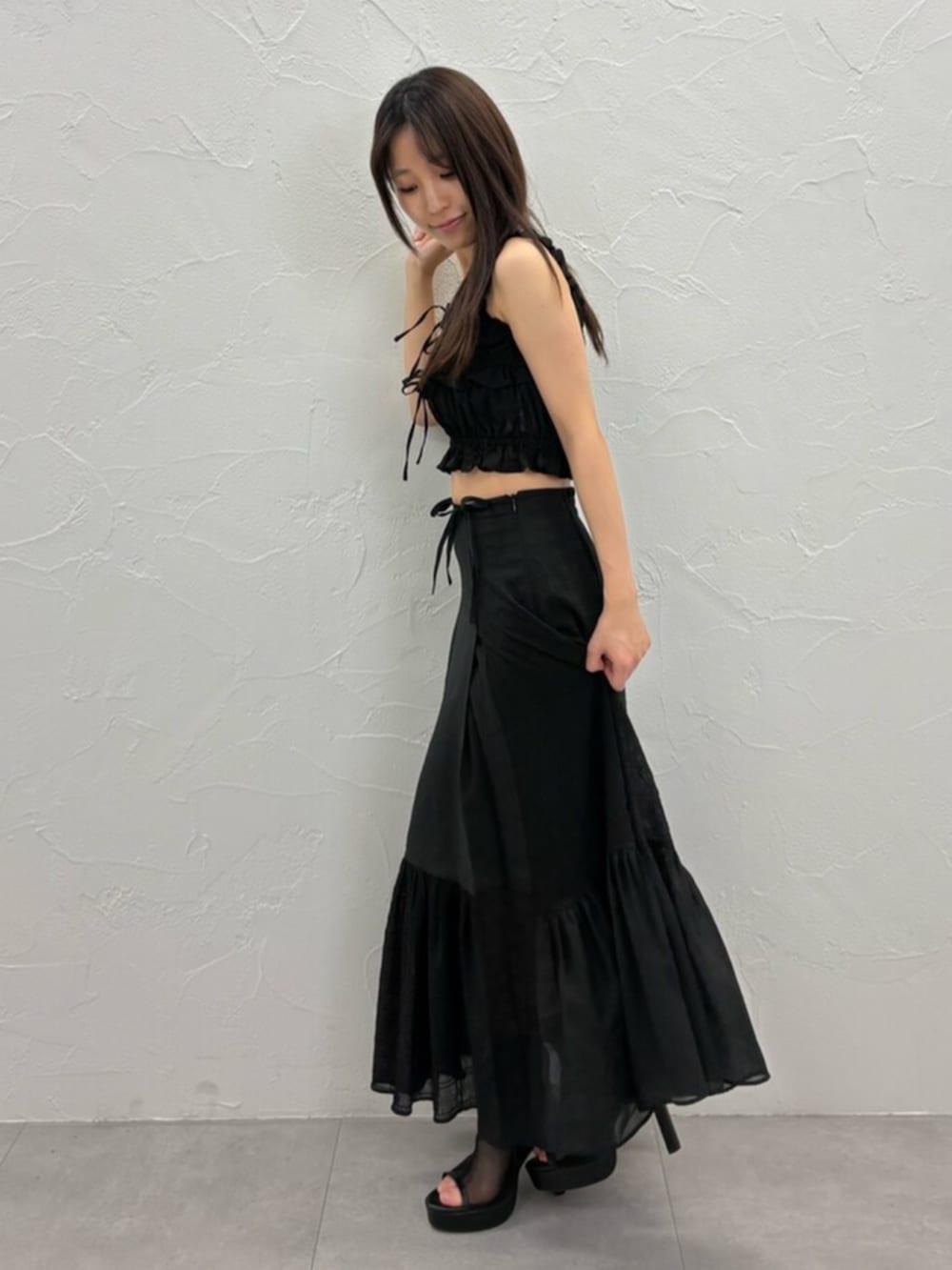ブラック系のサンダル、ブラック系のキャミソール、ブラック系のスカートを着用したレディースの夏コーディネートの2枚目の写真