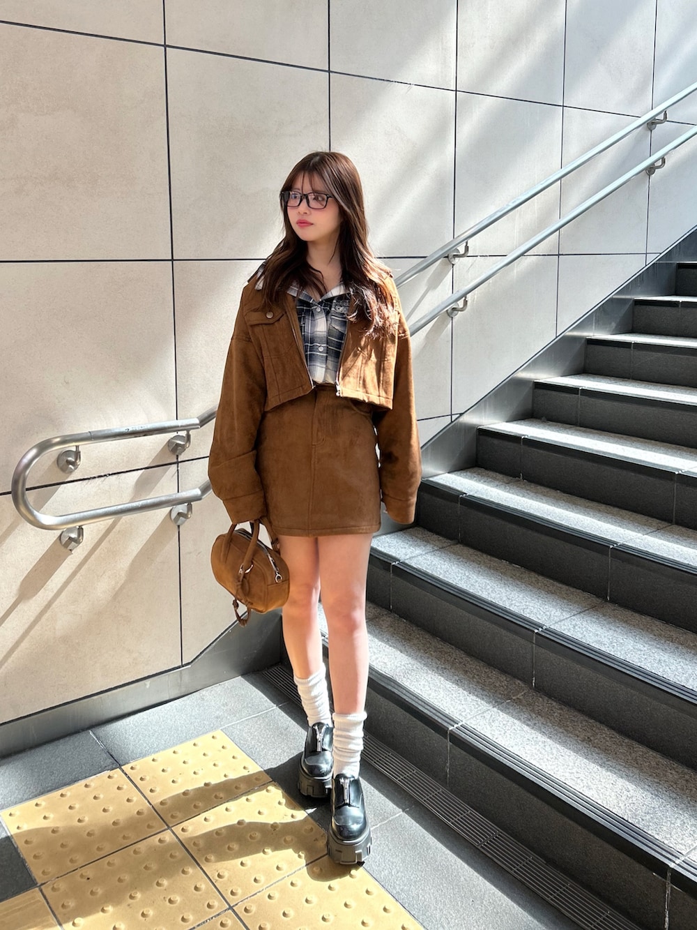 ブルー系のシャツ/ブラウス、イエロー系のスカート、イエロー系のブルゾンを着用したレディースの春コーディネートの2枚目の写真