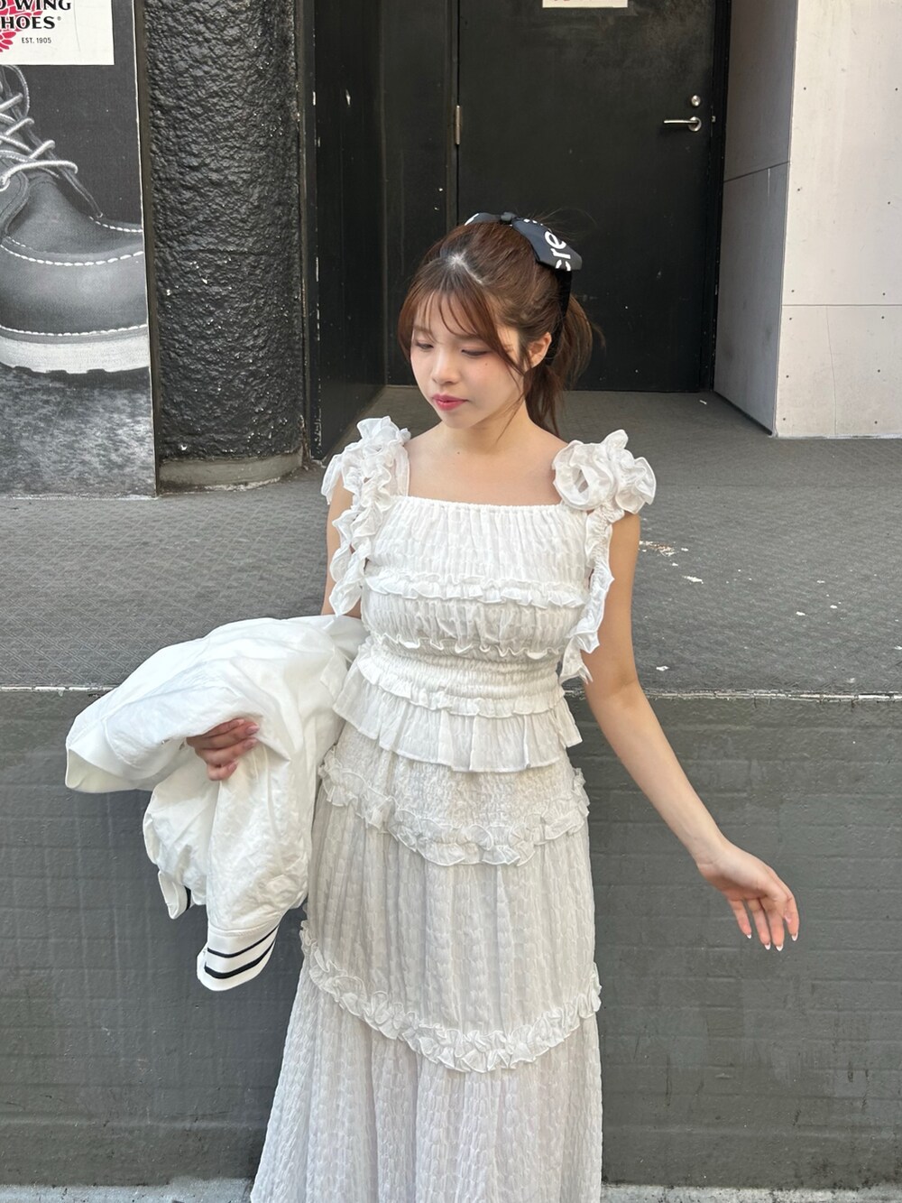 ホワイト系のワンピース、ホワイト系のブルゾンを着用したレディースの春コーディネートの3枚目の写真