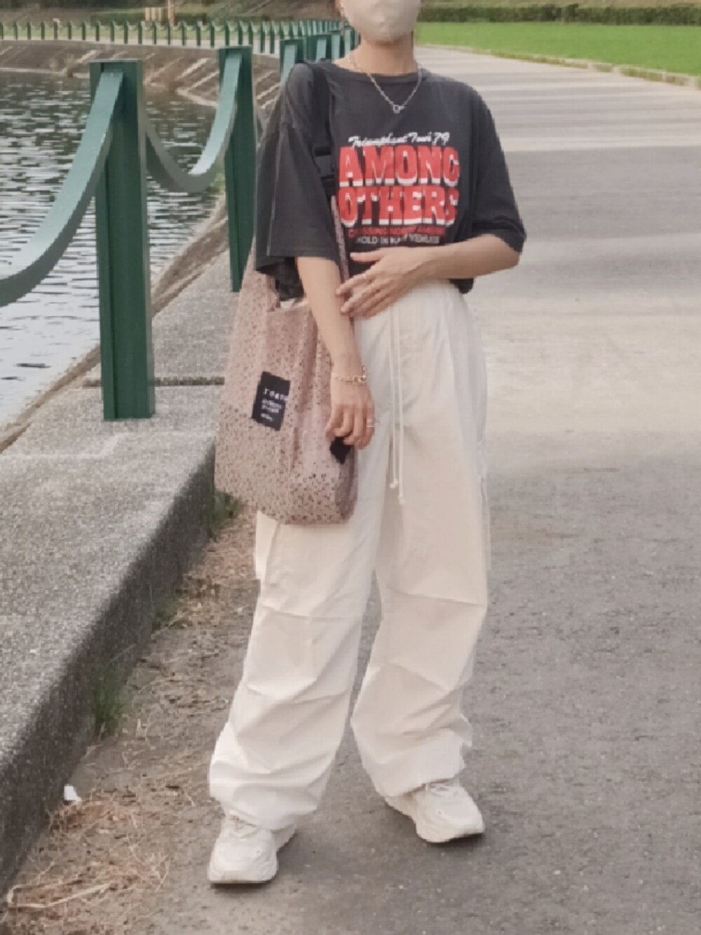 ホワイト系のチノパンツ、ホワイト系のスニーカー、グレー系のTシャツ/カットソーを着用したレディースの秋コーディネートの2枚目の写真