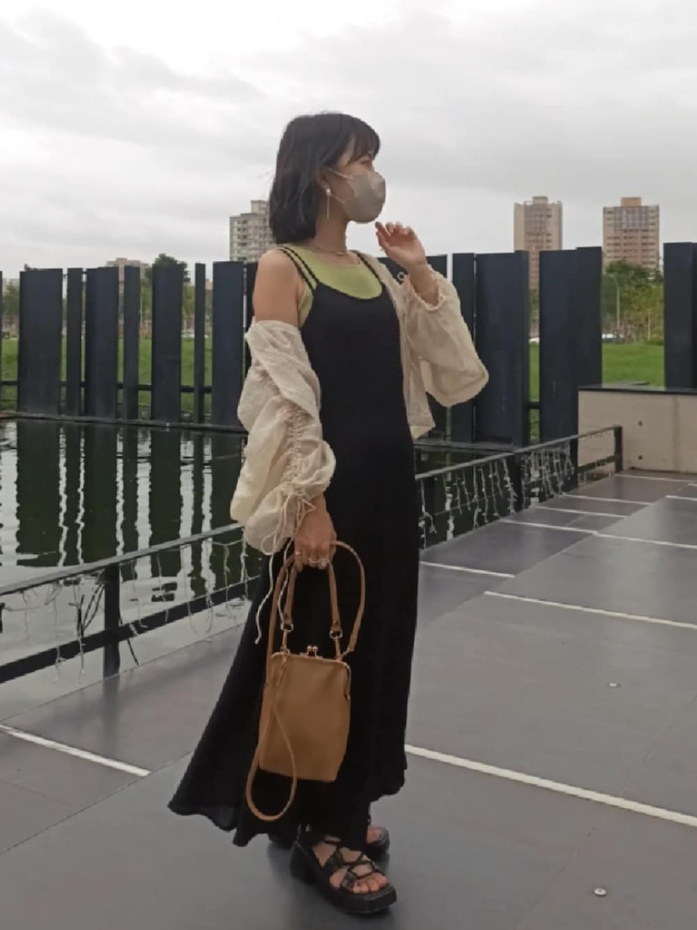 ブラック系のジャンパースカート、グリーン系のタンクトップ、ホワイト系のシャツ/ブラウスを着用したレディースの夏コーディネートの2枚目の写真