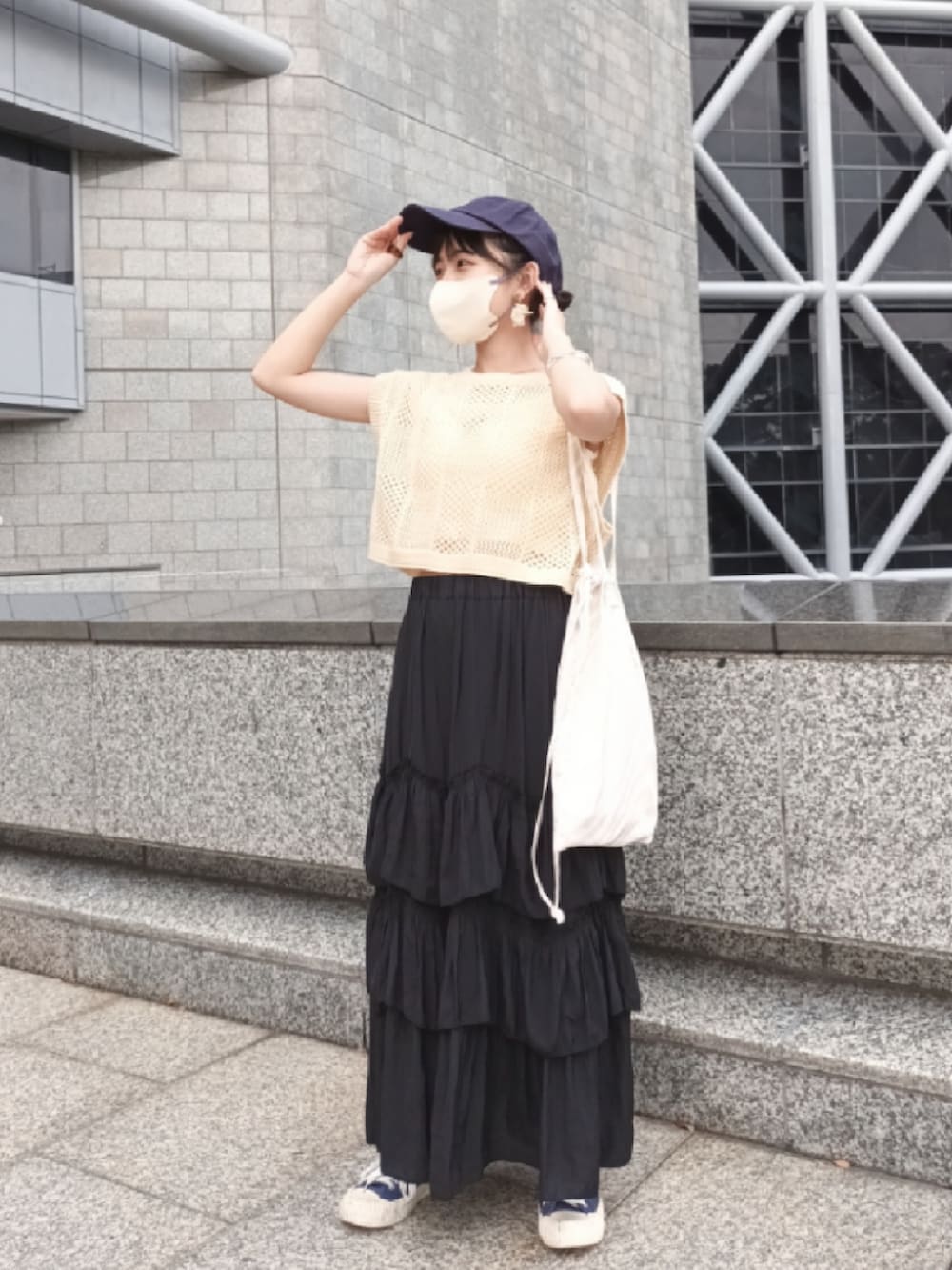 ブラック系のスカート、ベージュ系のトートバッグ、ブルー系のシューズを着用したレディースの秋コーディネートの2枚目の写真