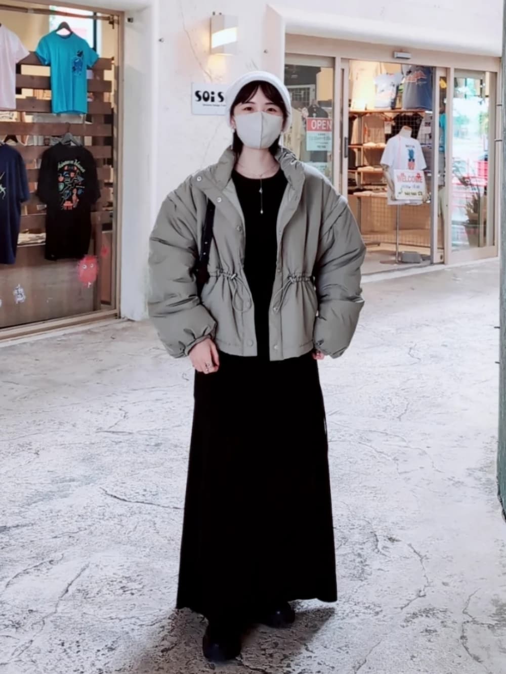 グリーン系のダウンジャケット/コート、ブラック系のワンピース、ブラック系のブーツを着用したレディースの冬コーディネートの2枚目の写真