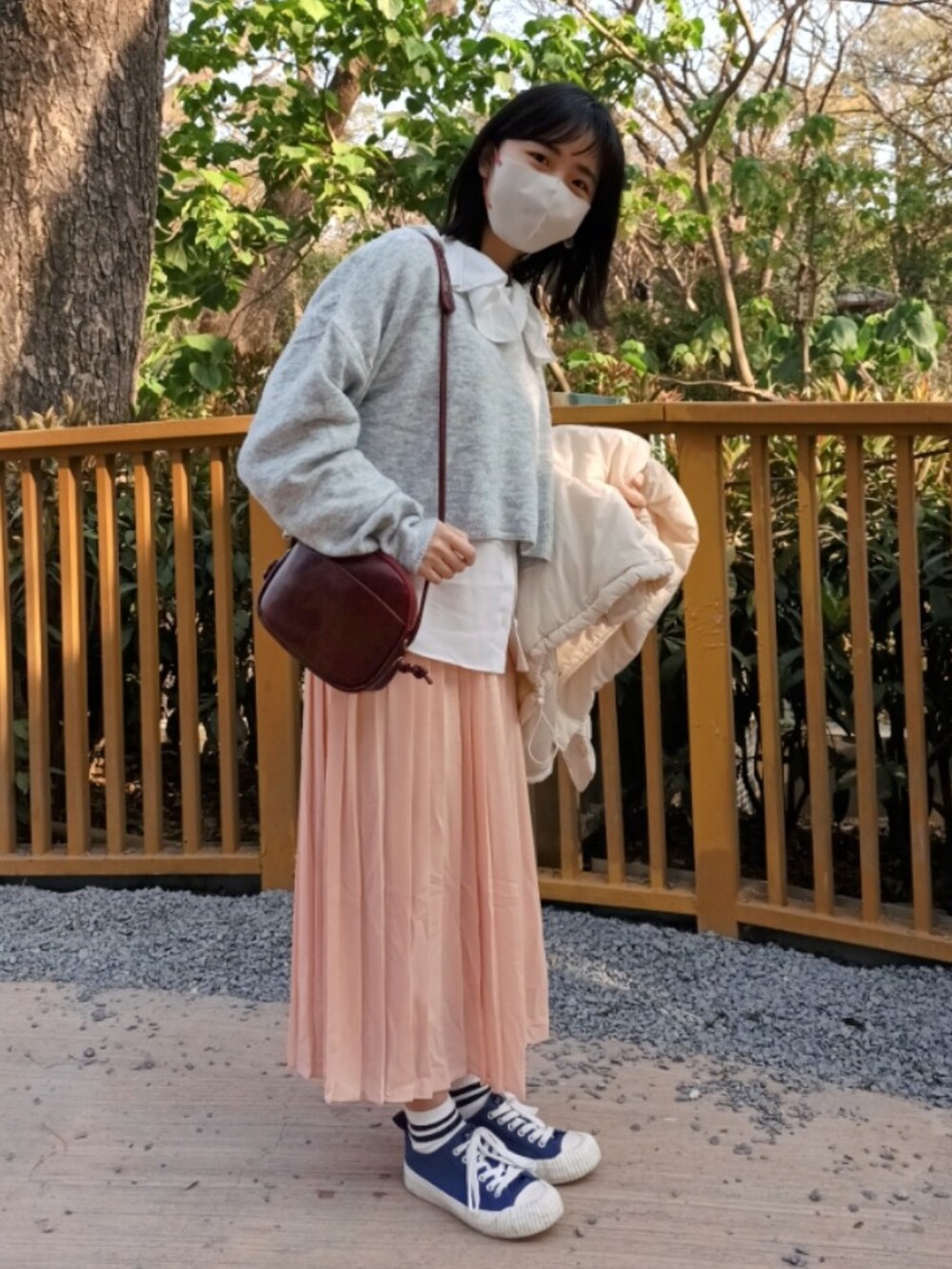 ブルー系のシューズ、グレー系のニット/セーター、ピンク系のスカートを着用したレディースの冬コーディネートの2枚目の写真