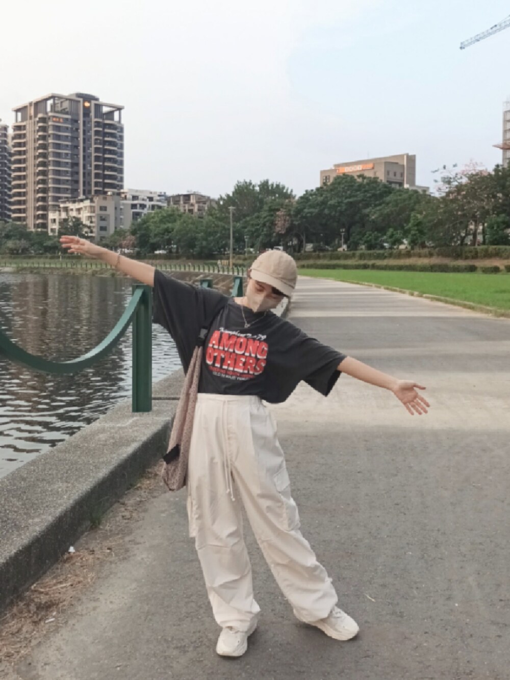 ホワイト系のチノパンツ、ホワイト系のスニーカー、グレー系のTシャツ/カットソーを着用したレディースの秋コーディネートの3枚目の写真