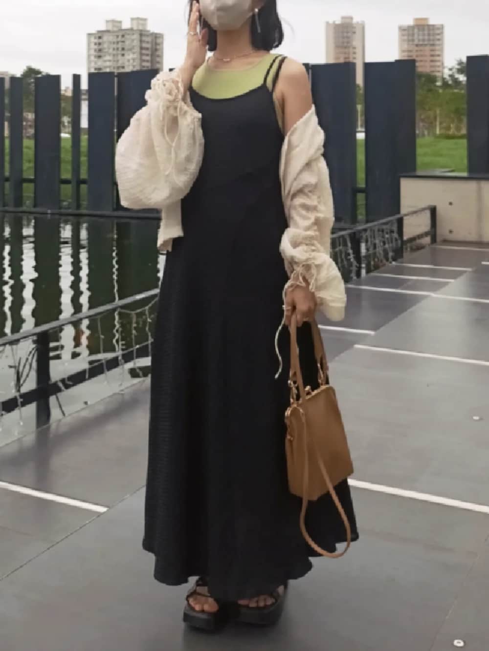 ブラック系のジャンパースカート、グリーン系のタンクトップ、ホワイト系のシャツ/ブラウスを着用したレディースの夏コーディネートの3枚目の写真