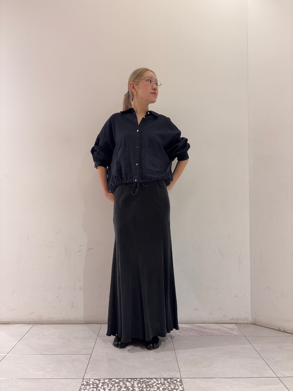 ブラック系のスカート、ブルー系のシャツ/ブラウスを着用したレディースの春コーディネートの2枚目の写真