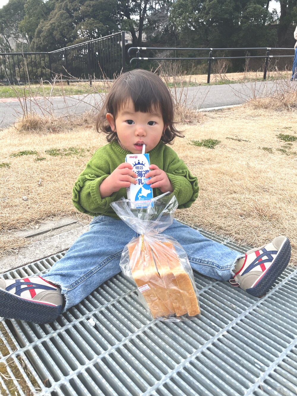 ブルー系のデニムパンツ、グリーン系のカーディガン/ボレロを着用したキッズの冬コーディネートの2枚目の写真