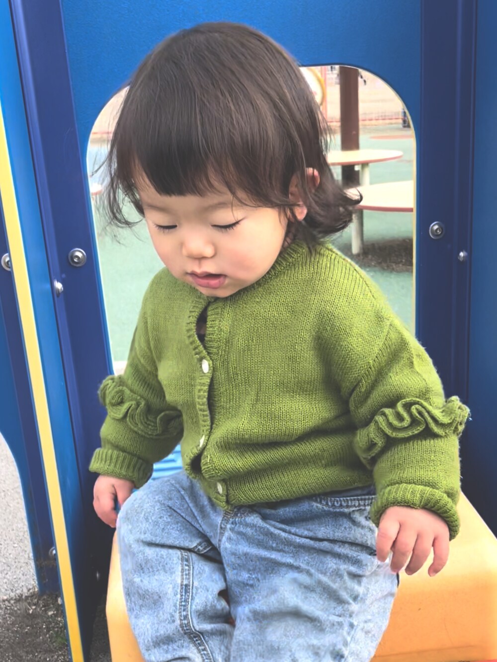 ブルー系のデニムパンツ、グリーン系のカーディガン/ボレロを着用したキッズの冬コーディネートの3枚目の写真