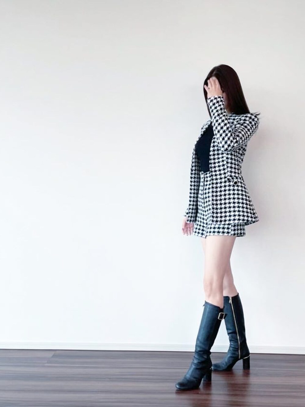 ブラック系のテーラードジャケット、ブラック系のブーツ、ブラック系のパンツを着用したレディースの秋コーディネートの2枚目の写真