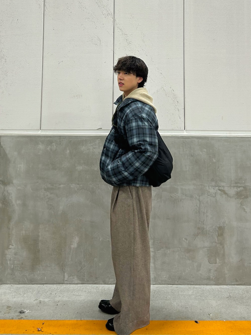 ブラック系のダウンジャケット/コート、その他のニット/セーター、ブラウン系のスラックスを着用したメンズの冬コーディネートの3枚目の写真