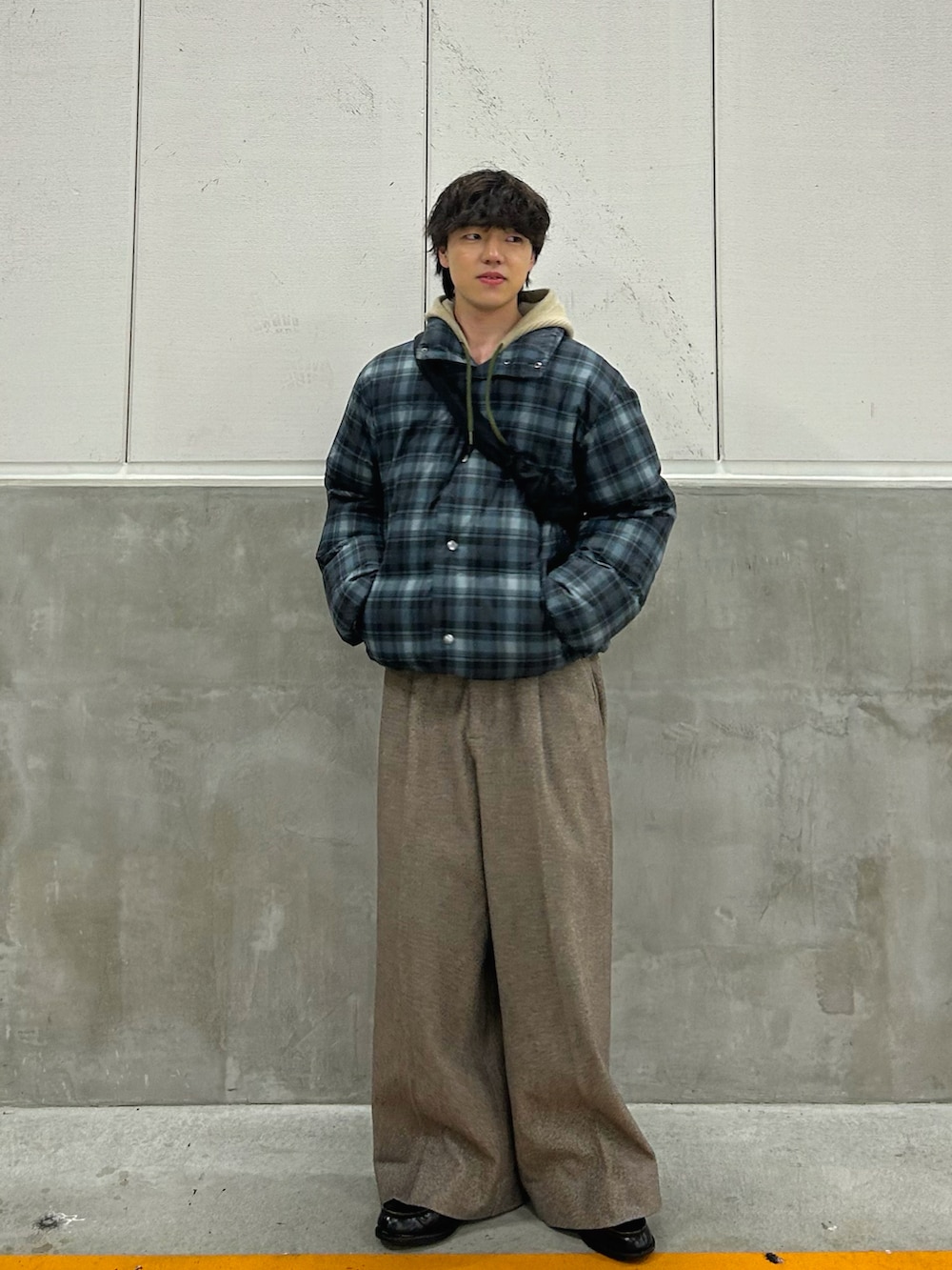 ブラック系のダウンジャケット/コート、その他のニット/セーター、ブラウン系のスラックスを着用したメンズの冬コーディネートの2枚目の写真