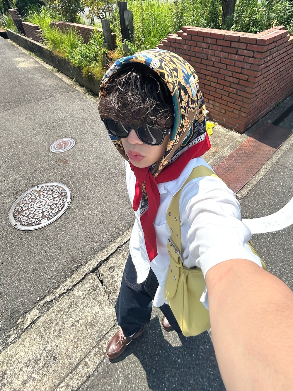 ホワイト系のシャツ/ブラウス、ブルー系のデニムパンツ、イエロー系のハンドバッグを着用したメンズの夏コーディネートの3枚目の写真