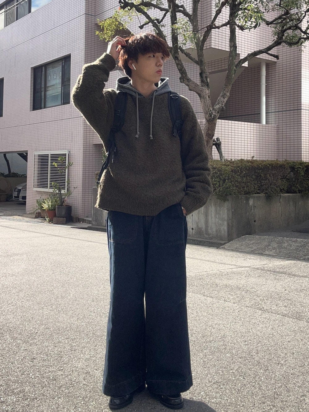 グリーン系のニット/セーター、ブルー系のデニムパンツ、ブラック系のローファーを着用したメンズの冬コーディネートの2枚目の写真