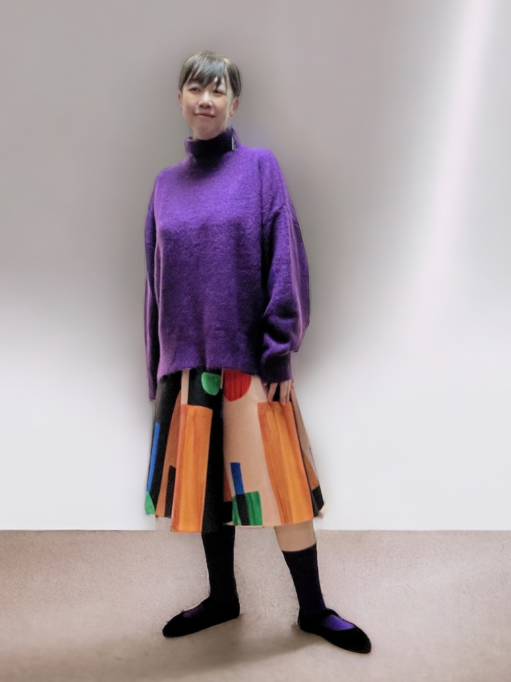 ブラック系のスカート、ブラック系のバレエシューズ、パープル系のニット/セーターを着用したレディースの冬コーディネートの2枚目の写真