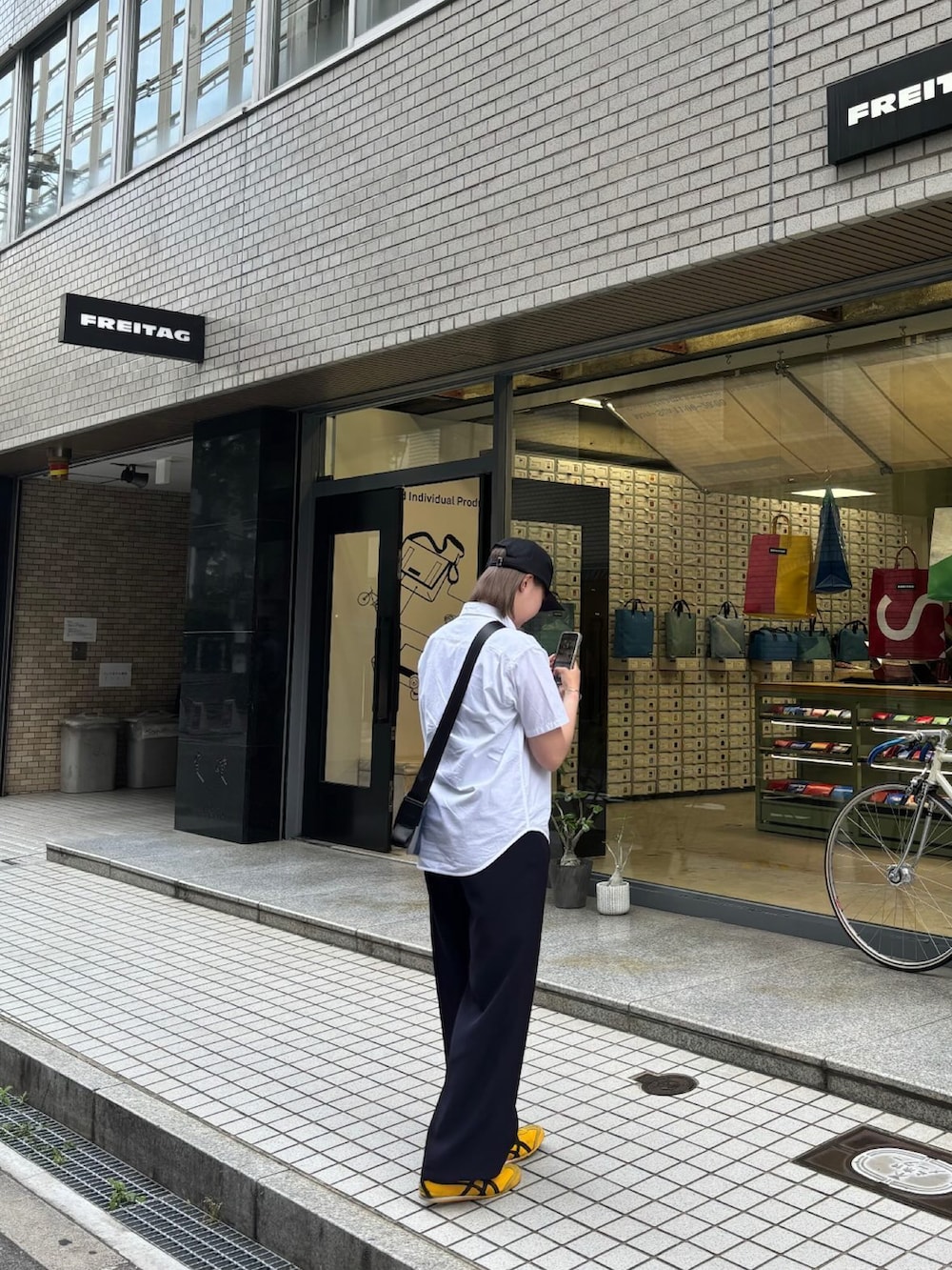 ホワイト系のシャツ/ブラウス、その他のショルダーバッグ、ブラック系のスラックスを着用したレディースの春コーディネートの2枚目の写真