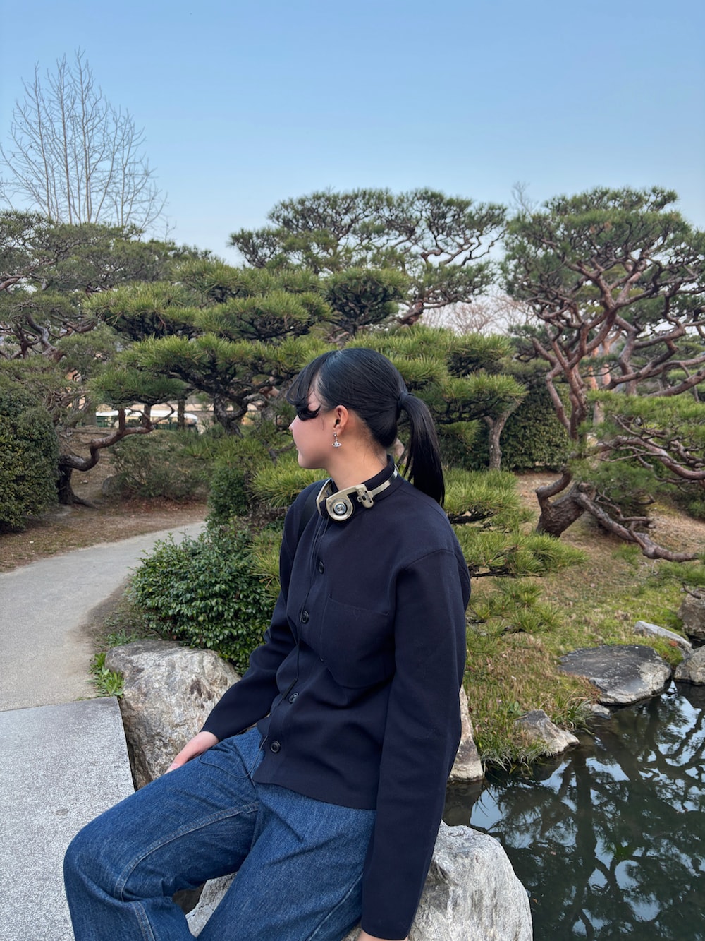 ブラック系のバックパック/リュック、レッド系のスニーカー、ブルー系のデニムパンツを着用したレディースの春コーディネートの2枚目の写真