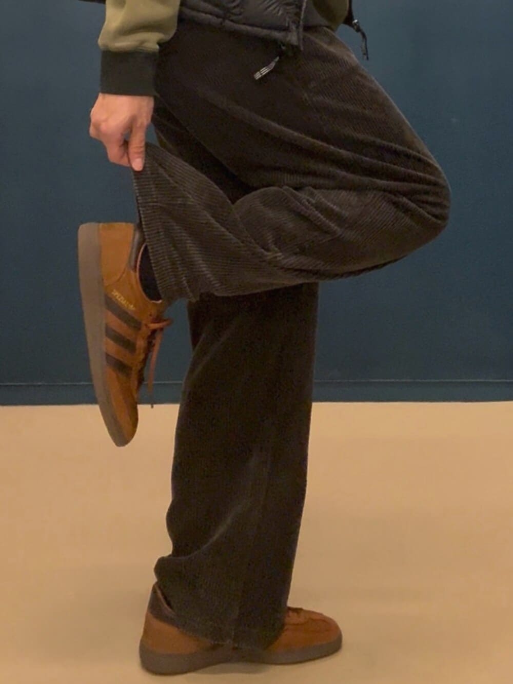 ブラウン系のスニーカー、ブラック系のジャケット/アウター、グリーン系のトップスを着用したメンズの冬コーディネートの2枚目の写真