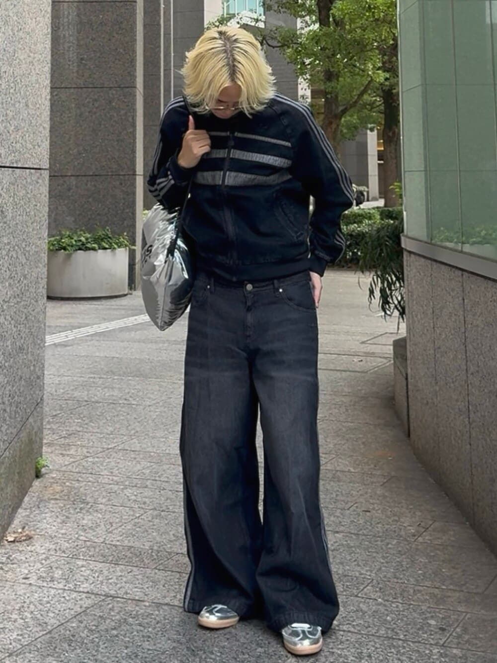 ブラック系のデニムパンツ、ブラック系のブルゾン、シルバー系のスニーカーを着用したメンズの秋コーディネートの2枚目の写真