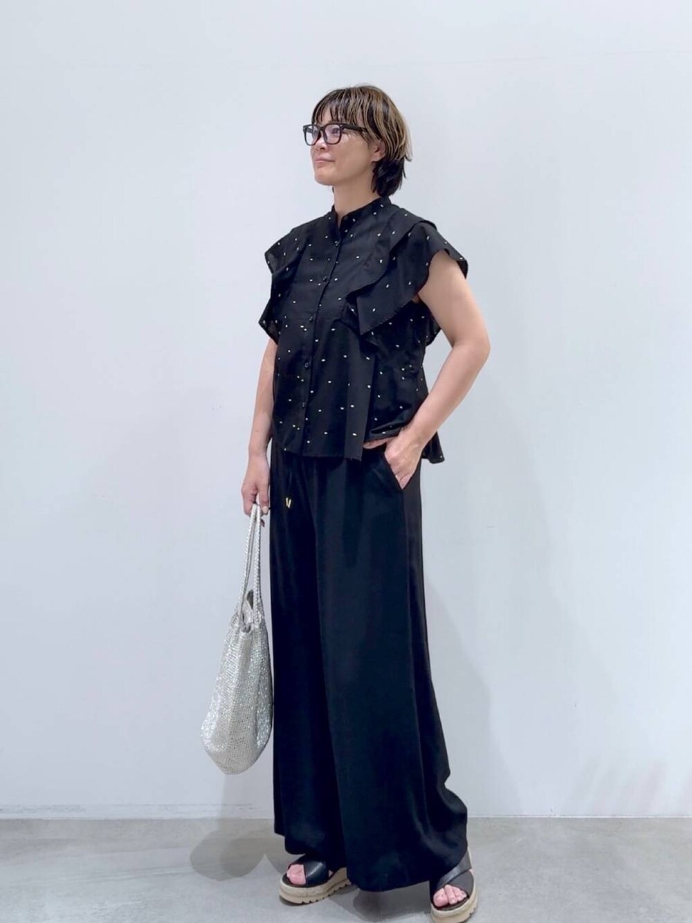 ブラック系のその他パンツ、ブラック系のその他パンツ、シルバー系のトートバッグを着用したレディースの夏コーディネートの3枚目の写真