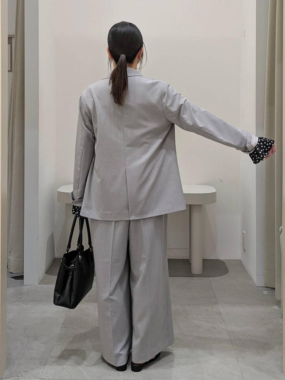 ブラック系のハンドバッグ、ブラック系のパンプス、グレー系のその他パンツを着用したレディースの冬コーディネートの4枚目の写真