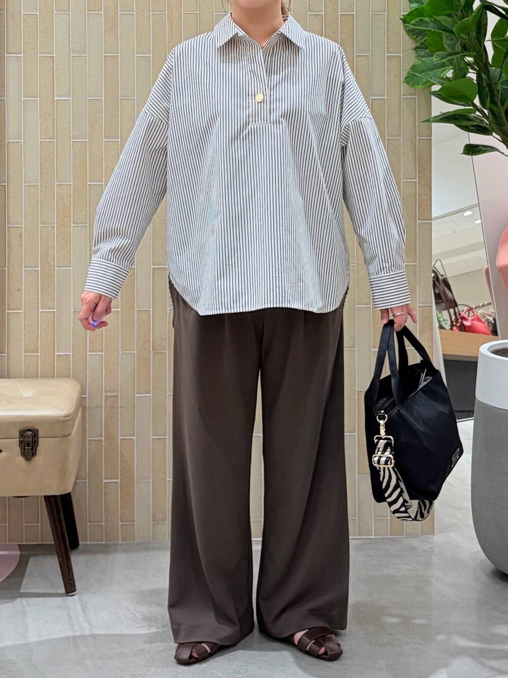 ブラウン系のその他パンツ、ブラウン系のシャツ/ブラウス、ブラック系のショルダーバッグを着用したレディースの春コーディネートの6枚目の写真