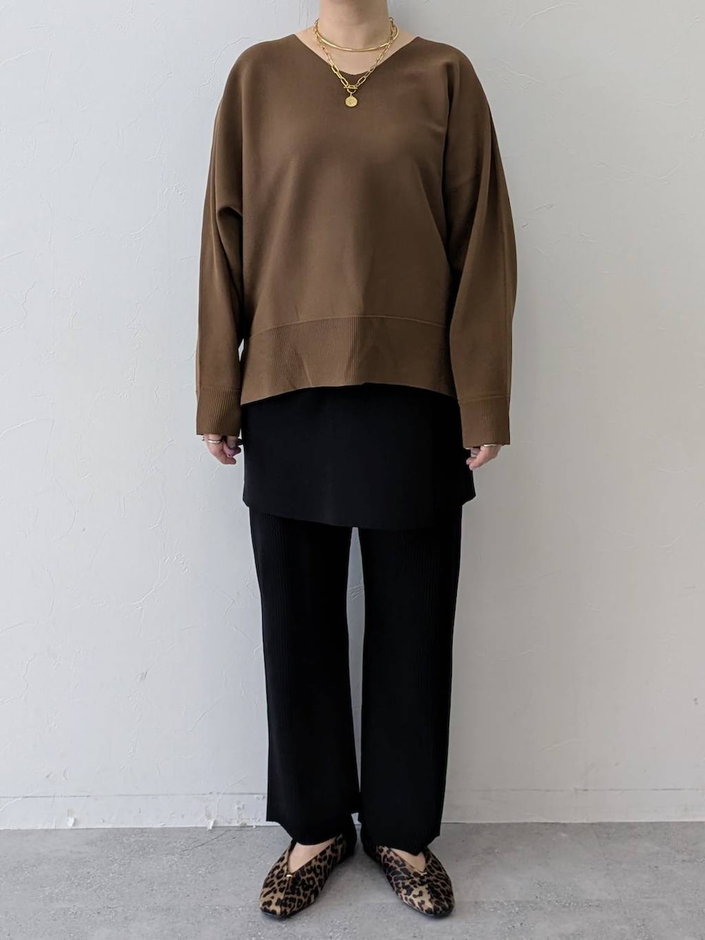 ブラウン系のパンプス、ブラック系のその他パンツ、ブラック系のスカートを着用したレディースの春コーディネートの6枚目の写真