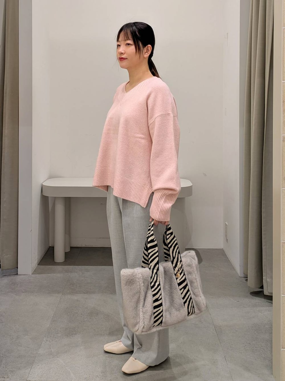 ホワイト系のパンプス、グレー系のその他パンツ、グレー系のトートバッグを着用したレディースの冬コーディネートの3枚目の写真