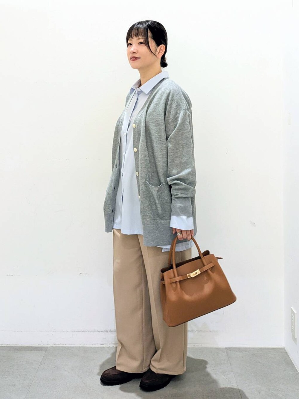 ブラウン系のハンドバッグ、ブルー系のシャツ/ブラウス、ベージュ系のその他パンツを着用したレディースの秋コーディネートの3枚目の写真