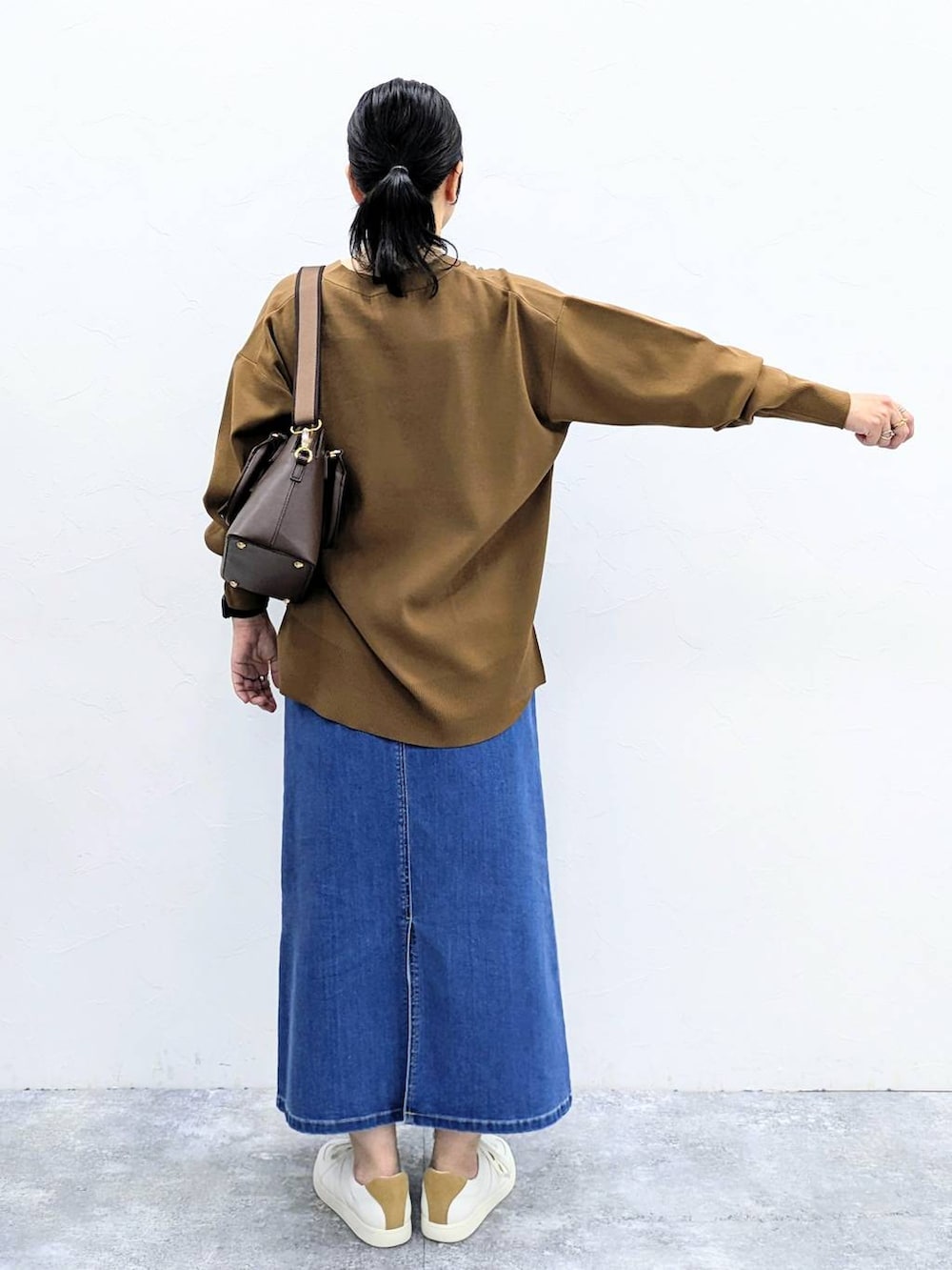 ブラウン系のカーディガン/ボレロ、ブルー系のデニムスカートを着用したレディースの夏コーディネートの4枚目の写真