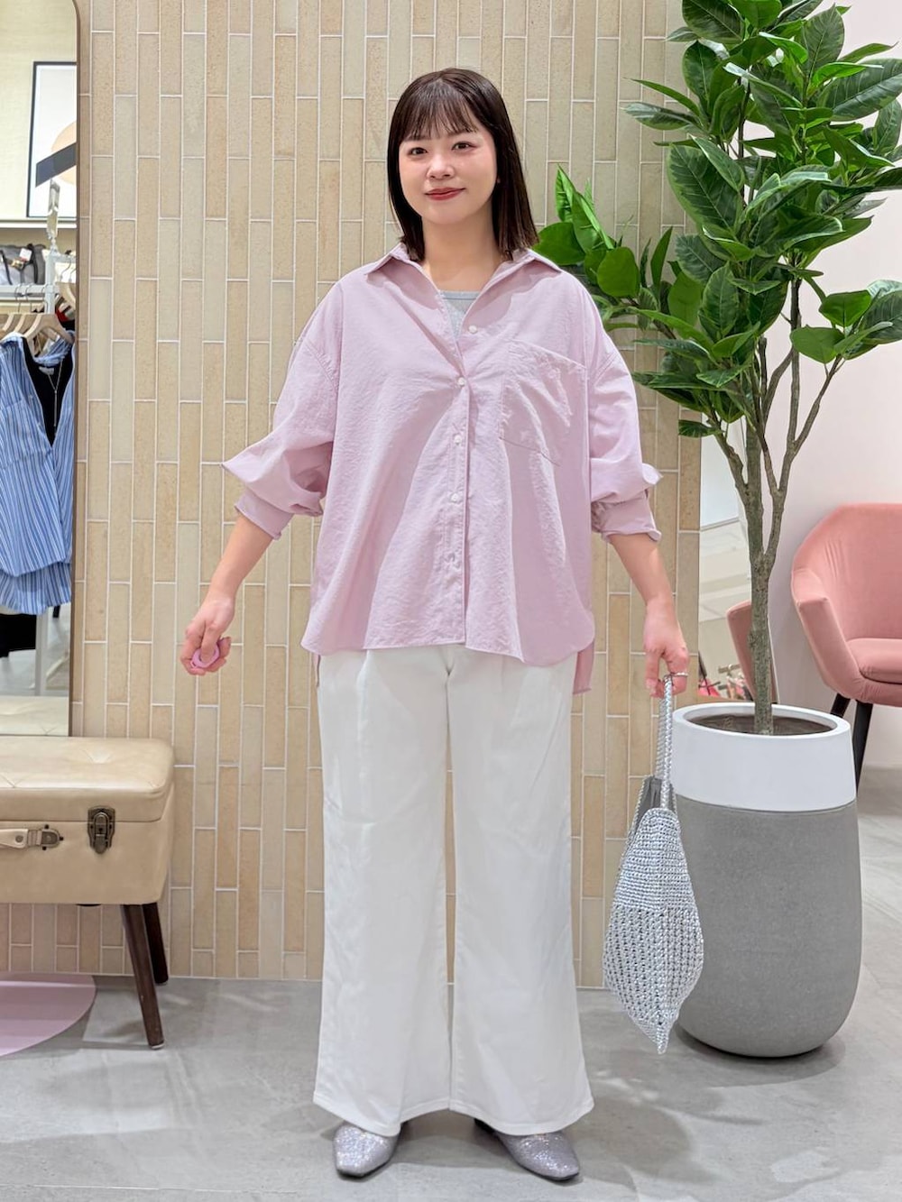 ホワイト系のデニムパンツ、ピンク系のシャツ/ブラウス、シルバー系のトートバッグを着用したレディースの春コーディネートの2枚目の写真