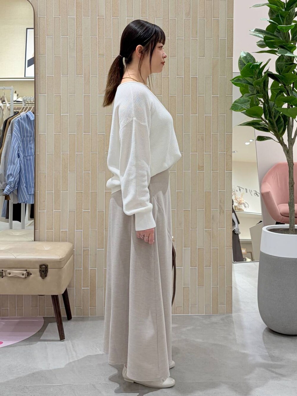 ホワイト系のニット/セーター、ブラウン系のハンドバッグ、ベージュ系のスカートを着用したレディースの春コーディネートの5枚目の写真