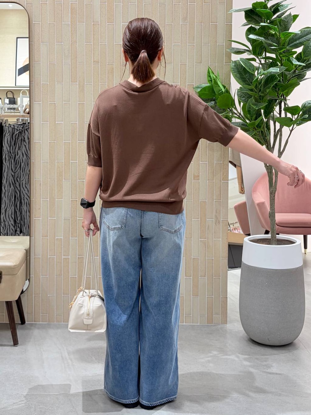 ブラウン系のニット/セーター、ブルー系のデニムパンツ、シルバー系のメガネを着用したレディースの夏コーディネートの4枚目の写真