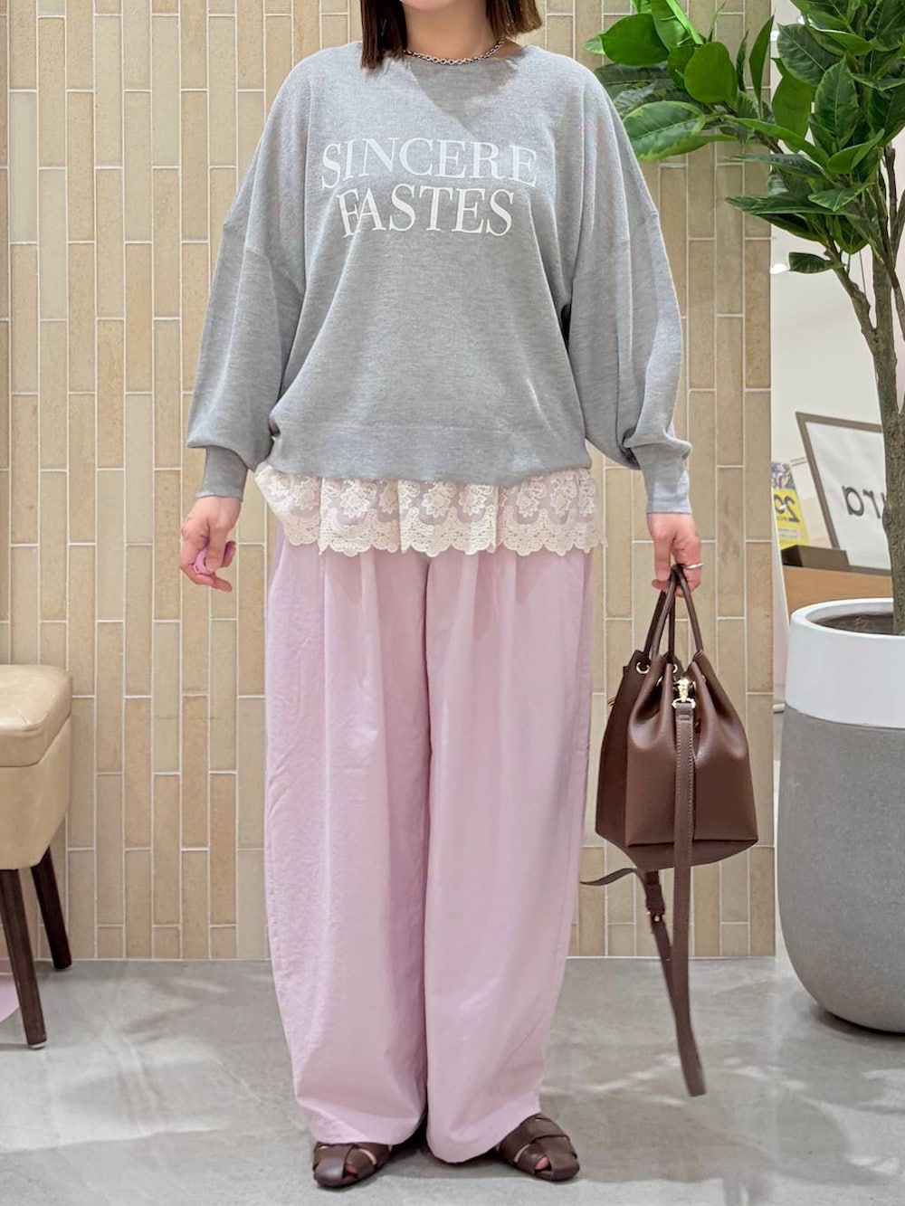 ホワイト系のタンクトップ、ピンク系のその他パンツ、ブラウン系のハンドバッグを着用したレディースの春コーディネートの6枚目の写真