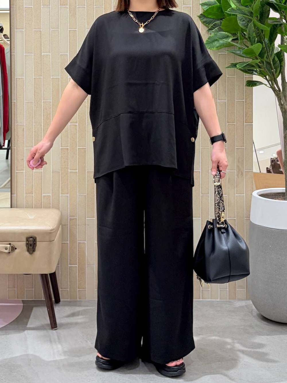 ブラック系のハンドバッグ、ブラック系のその他パンツ、ブラック系のシャツ/ブラウスを着用したレディースの春コーディネートの6枚目の写真