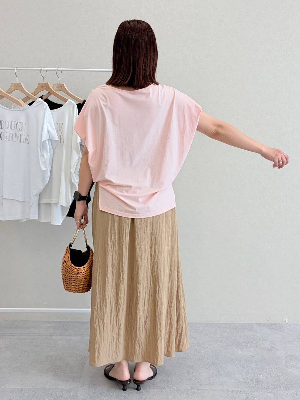 ブラウン系のかごバッグ、ピンク系のTシャツ/カットソーを着用したレディースの夏コーディネートの4枚目の写真