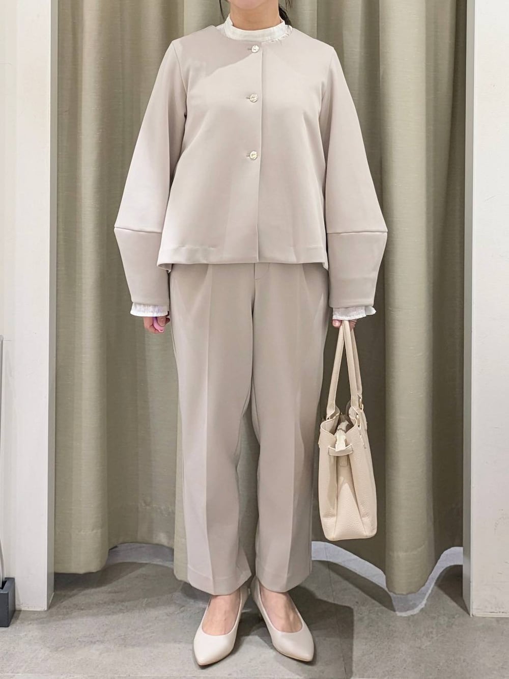 ホワイト系のパンプス、ホワイト系のシャツ/ブラウス、ベージュ系のノーカラージャケットを着用したレディースの冬コーディネートの7枚目の写真