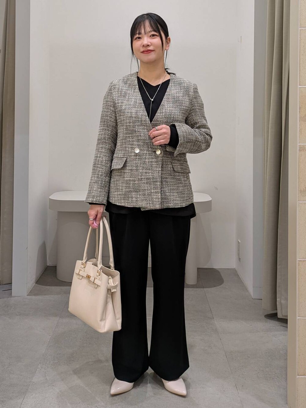 ホワイト系のパンプス、ブラック系のその他パンツ、ブラック系のノーカラージャケットを着用したレディースの冬コーディネートの6枚目の写真