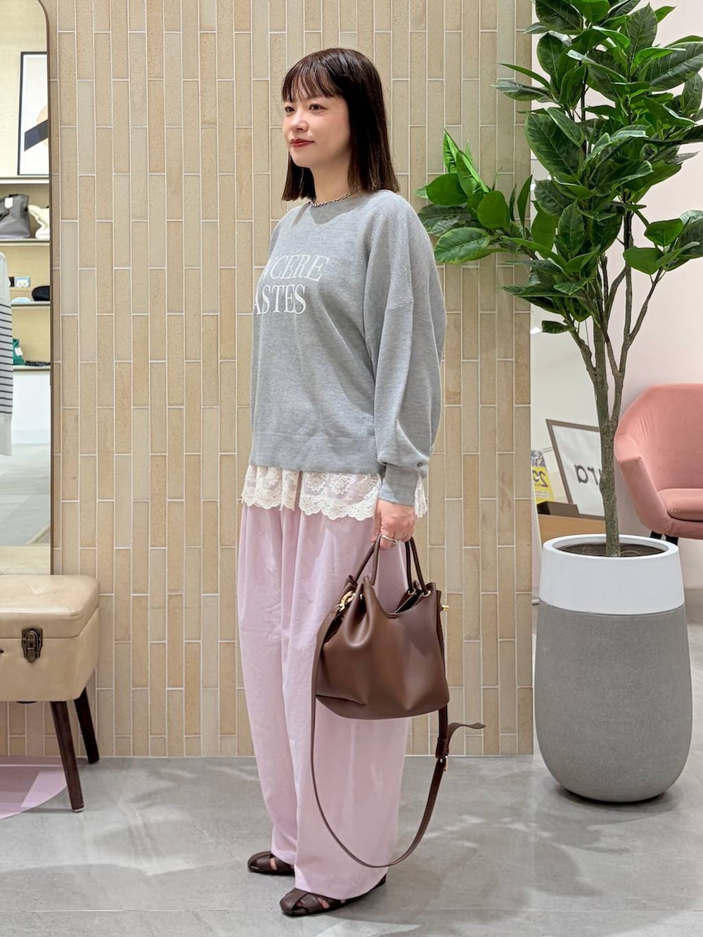 ホワイト系のタンクトップ、ピンク系のその他パンツ、ブラウン系のハンドバッグを着用したレディースの春コーディネートの3枚目の写真