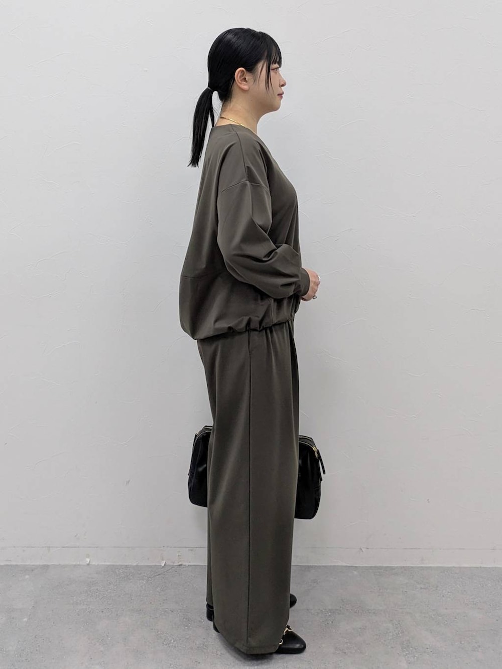 ブラック系のボストンバッグ、ブラック系のパンプス、グリーン系のその他パンツを着用したレディースの冬コーディネートの5枚目の写真