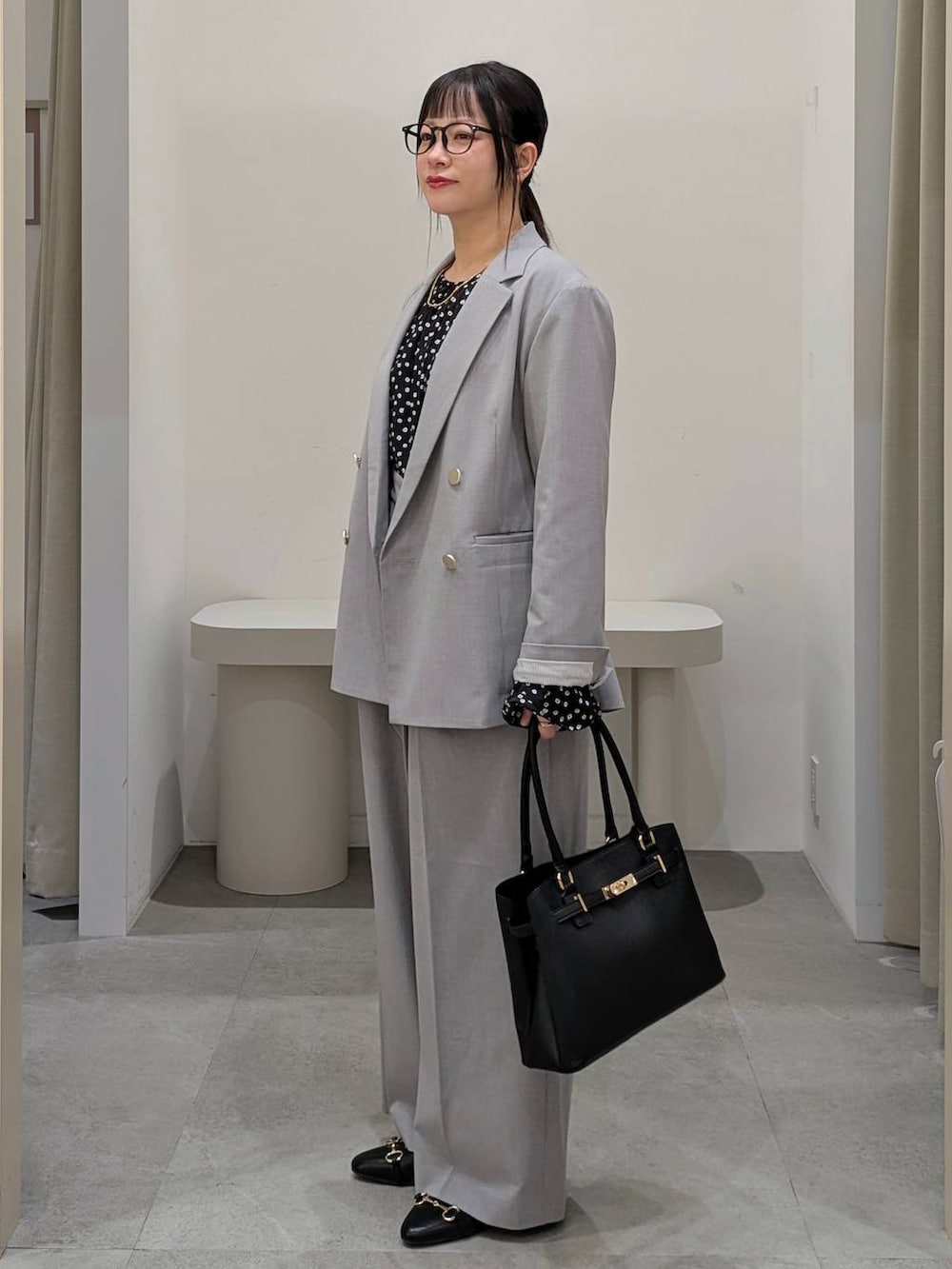 ブラック系のハンドバッグ、ブラック系のパンプス、グレー系のその他パンツを着用したレディースの冬コーディネートの3枚目の写真