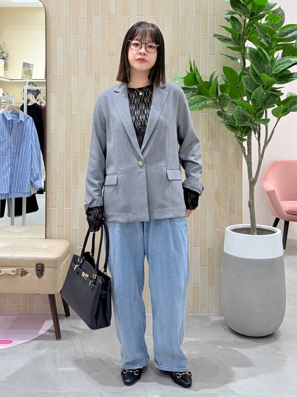 ブルー系のデニムパンツ、ブラック系のハンドバッグ、ブラック系のパンプスを着用したレディースの春コーディネートの2枚目の写真