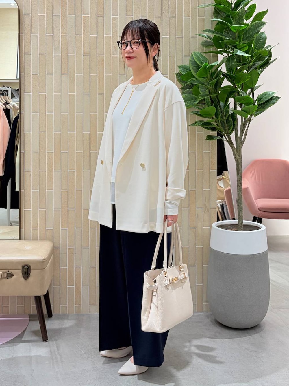 ホワイト系のパンプス、ブルー系のスラックス、ホワイト系のハンドバッグを着用したレディースの春コーディネートの3枚目の写真