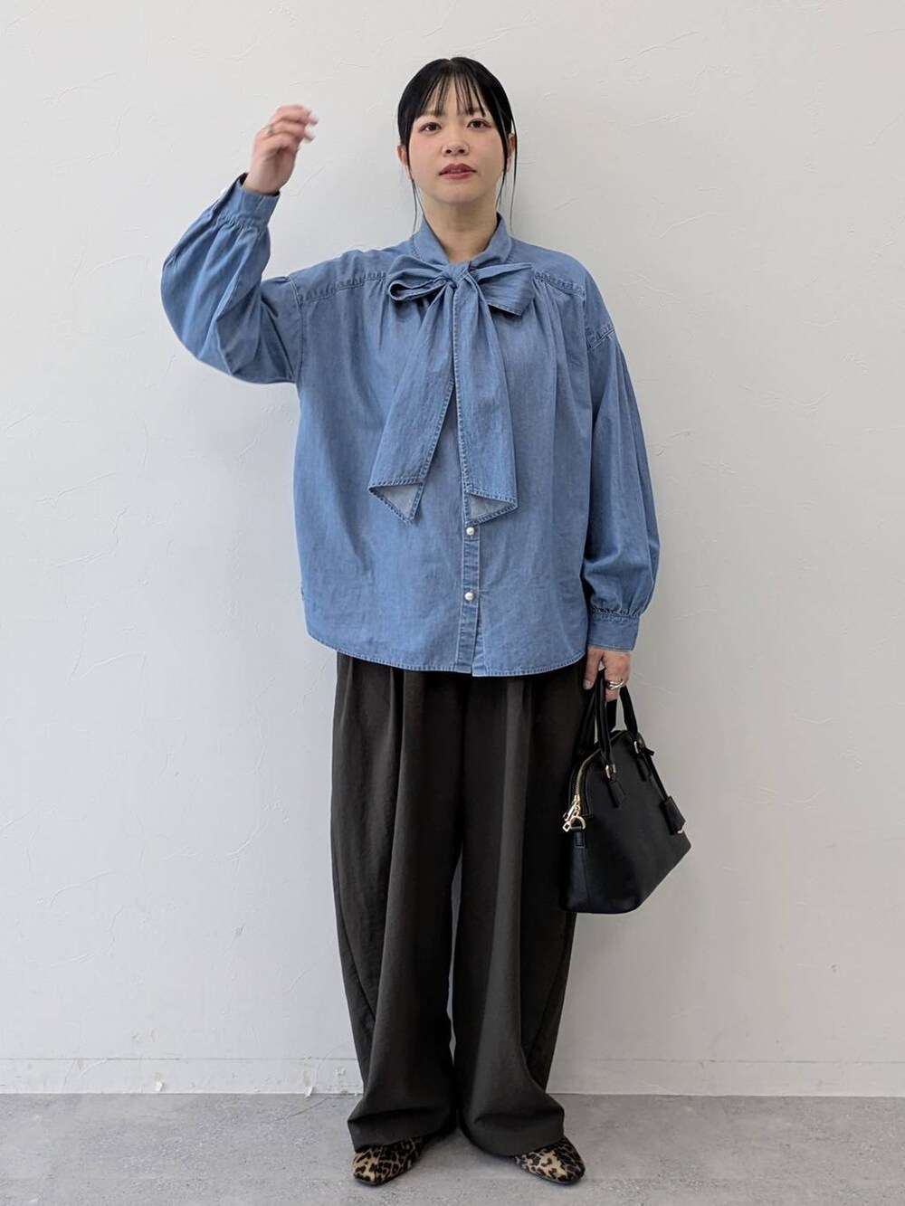 ブラック系のハンドバッグ、ブラウン系のパンプス、ブラウン系のその他パンツを着用したレディースの冬コーディネートの2枚目の写真