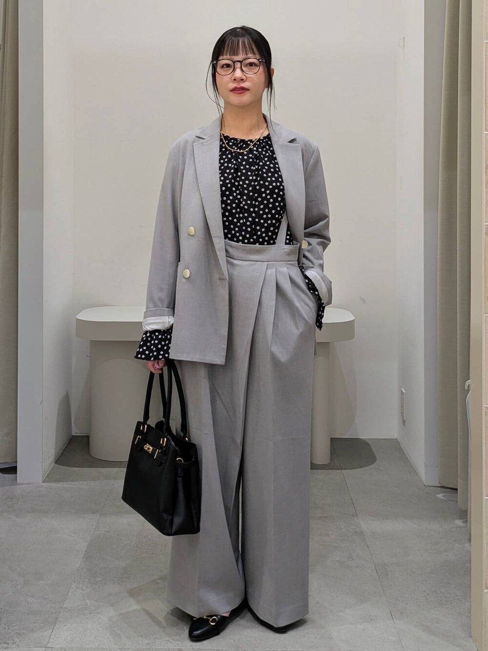 ブラック系のハンドバッグ、ブラック系のパンプス、グレー系のその他パンツを着用したレディースの冬コーディネートの2枚目の写真