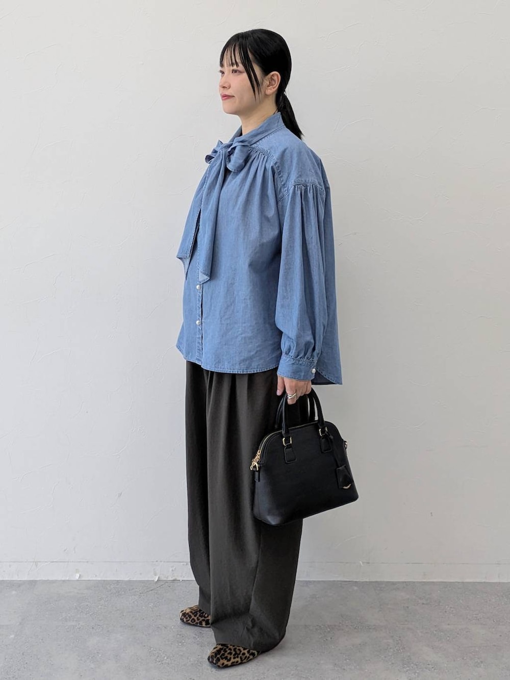 ブラック系のハンドバッグ、ブラウン系のパンプス、ブラウン系のその他パンツを着用したレディースの冬コーディネートの3枚目の写真