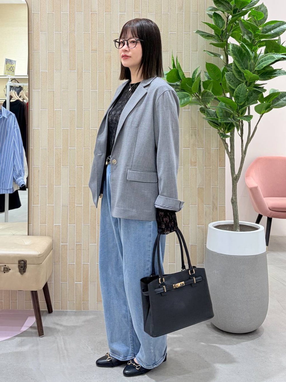 ブルー系のデニムパンツ、ブラック系のハンドバッグ、ブラック系のパンプスを着用したレディースの春コーディネートの3枚目の写真